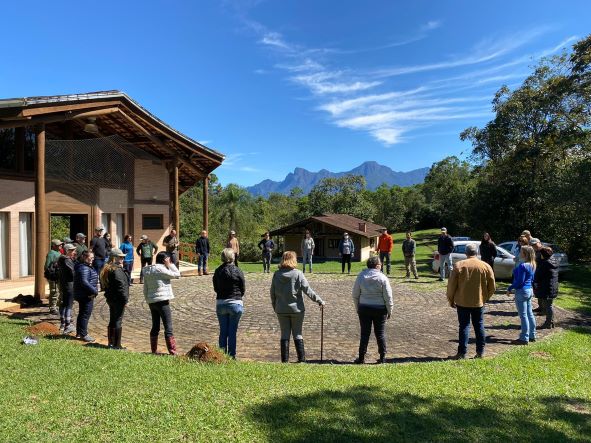 Imagem dos participantes em círculo na área aberta da Reserva.