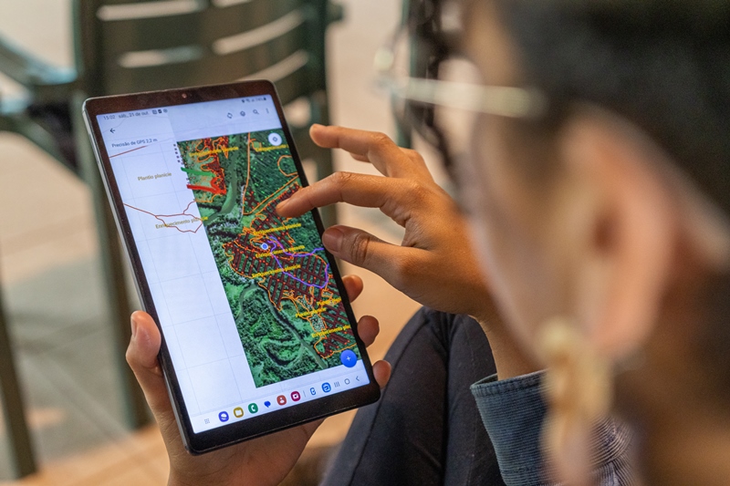 Imagem de uma pessoa usando um tablet com mapa.