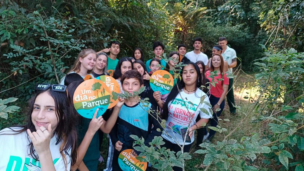 Imagem de jovens posando para a foto em meio a floresta.