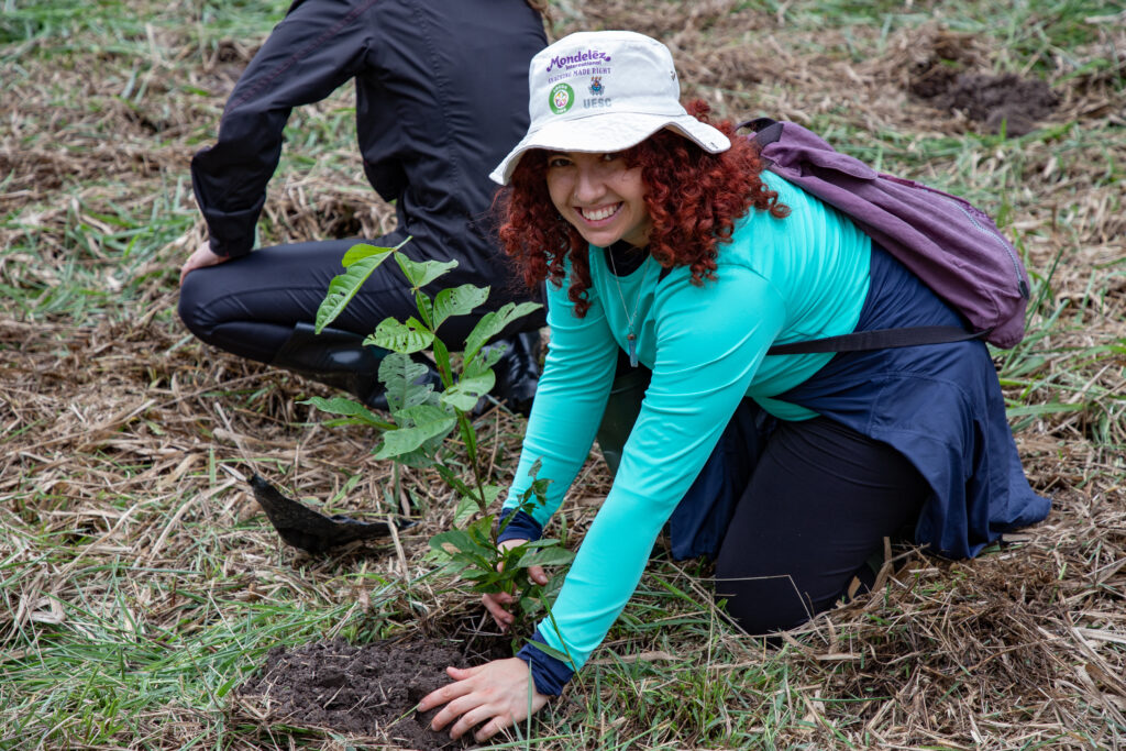 Imagem de mulher plantando muda.
