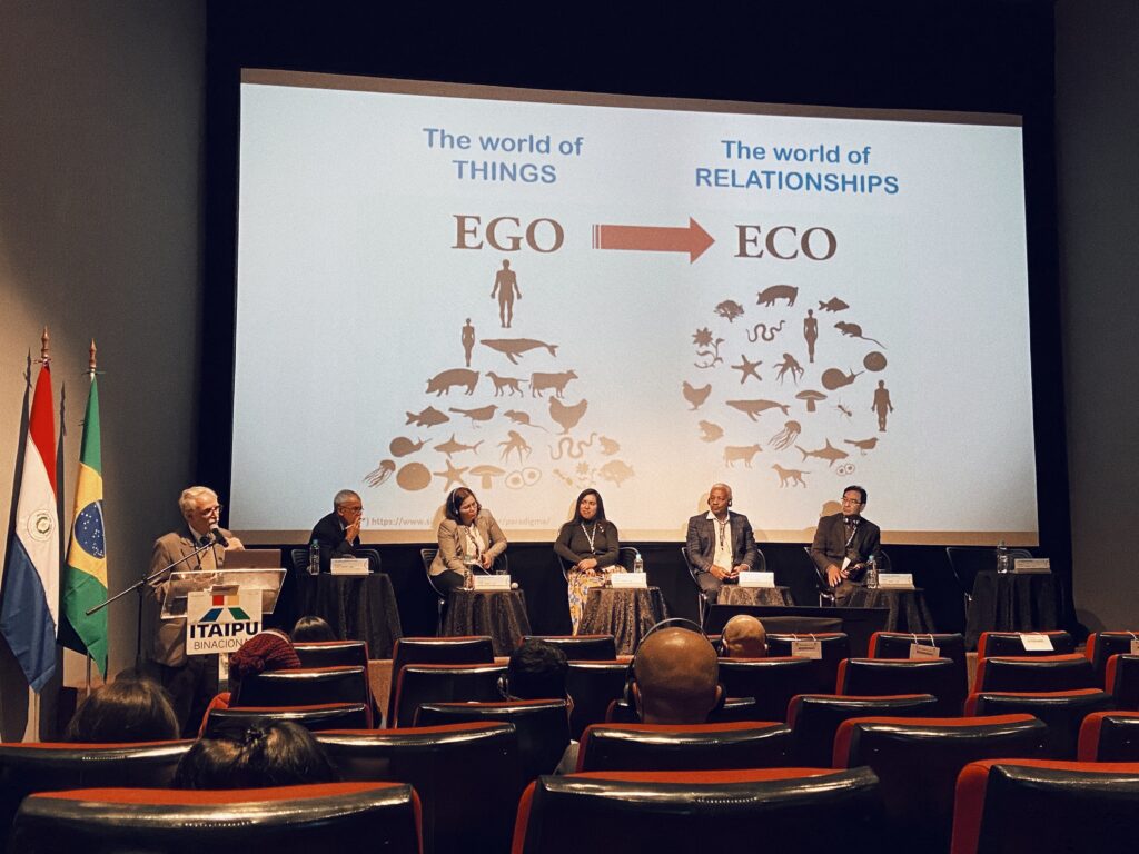 Imagem de pessoas sentadas a frente de um telão de apresentação.