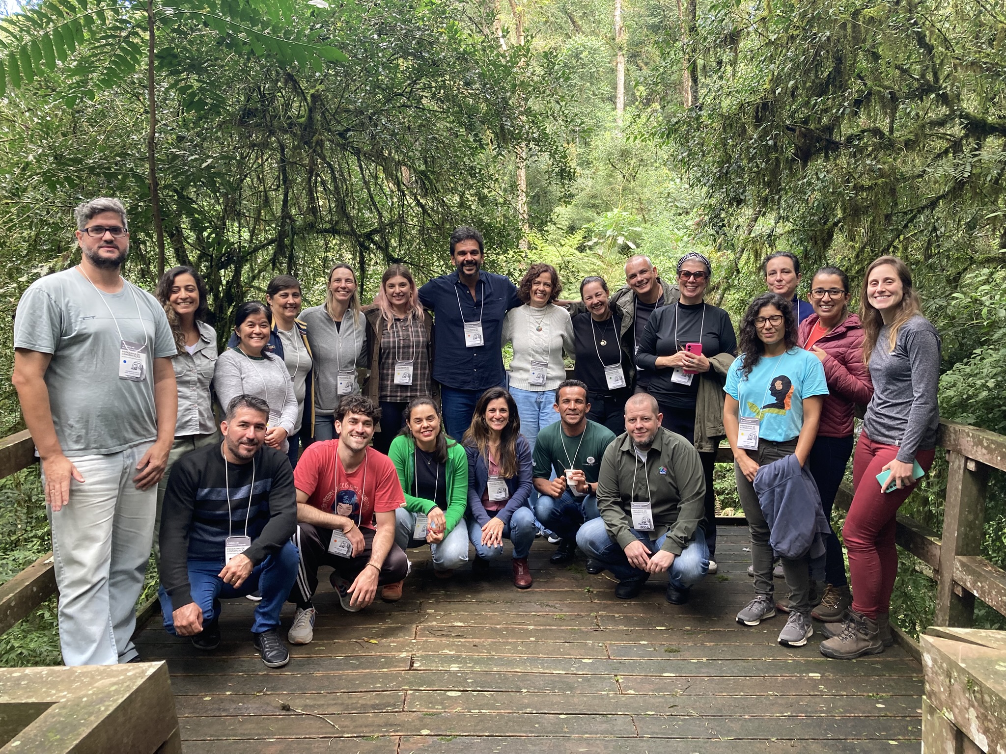 Imagem com 21 pesquisadores, alguns em pé e outros agachados, em uma estrutura de madeira em meio a floresta da RPPN (Reserva Particular do Patrimônio Natural) Airumã.